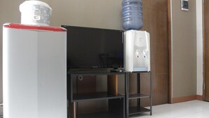 A kitchenette with a refrigerator, a microwave, and a water dispenser. - Pleasant 2BR Apartment at Gateway Ahmad Yani (Bandung)