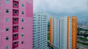 Un edificio alto con varios pisos, ventanas amplias y una llamativa franja anaranjada.