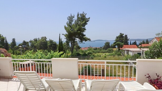 A terrace with white chairs and a view of the sea. - Apartments Villa Michele (Orebic)