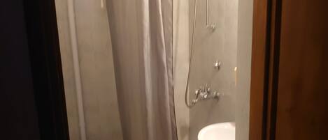 Une salle de bain avec des toilettes, une douche et un lavabo.