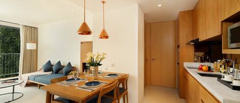 A modern kitchen with wooden cabinets, a dining table with chairs, and pendant lights.