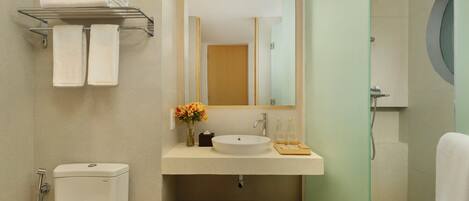 A bathroom with a toilet, a sink with a mirror, a towel rack, and a hairdryer.