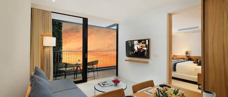 A modern hotel room with a balcony, a dining area, and a bedroom.