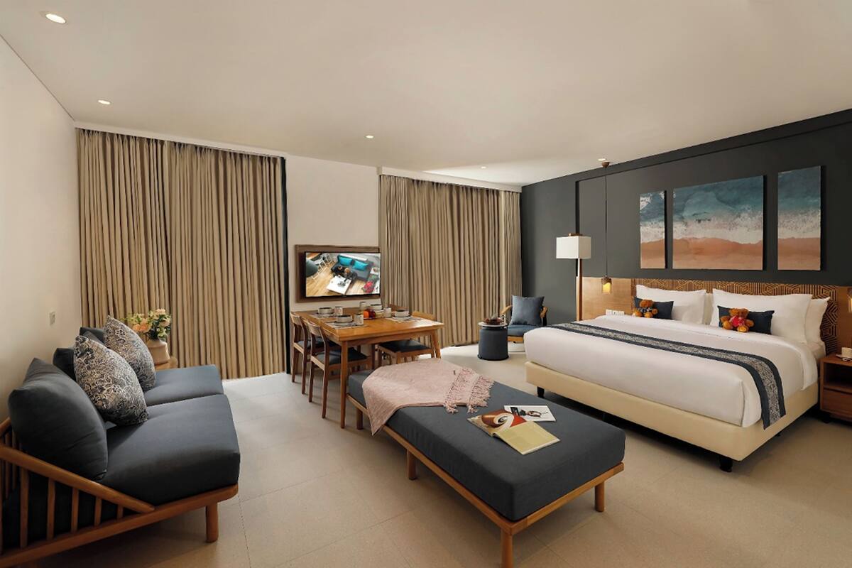 Una habitación de hotel moderna con una cama grande, un sofá, un escritorio y un televisor.