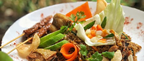 Een bord eten met diverse ingrediënten, waaronder vlees, groenten en een gebakken ei.