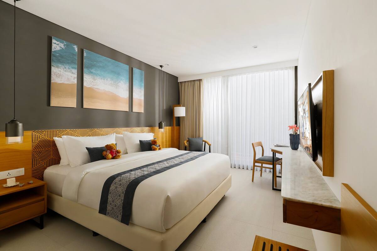 Una habitación de hotel moderna con una cama grande, un escritorio y una televisión.