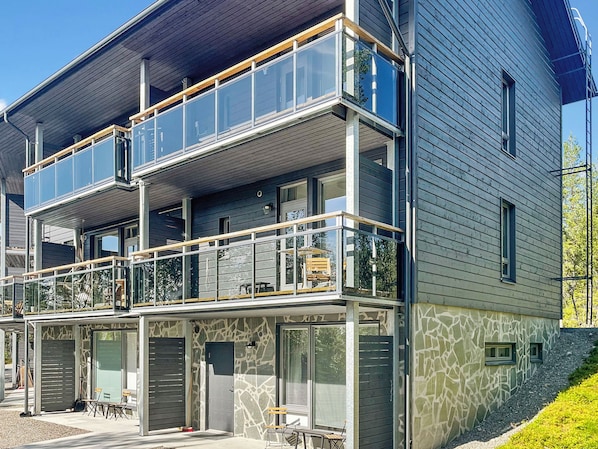 Un immeuble à plusieurs étages doté d’un balcon, de grandes fenêtres et d’une façade en pierre.