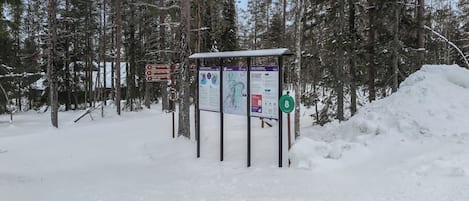 A snow-covered outdoor area with informational signs and a shelter.