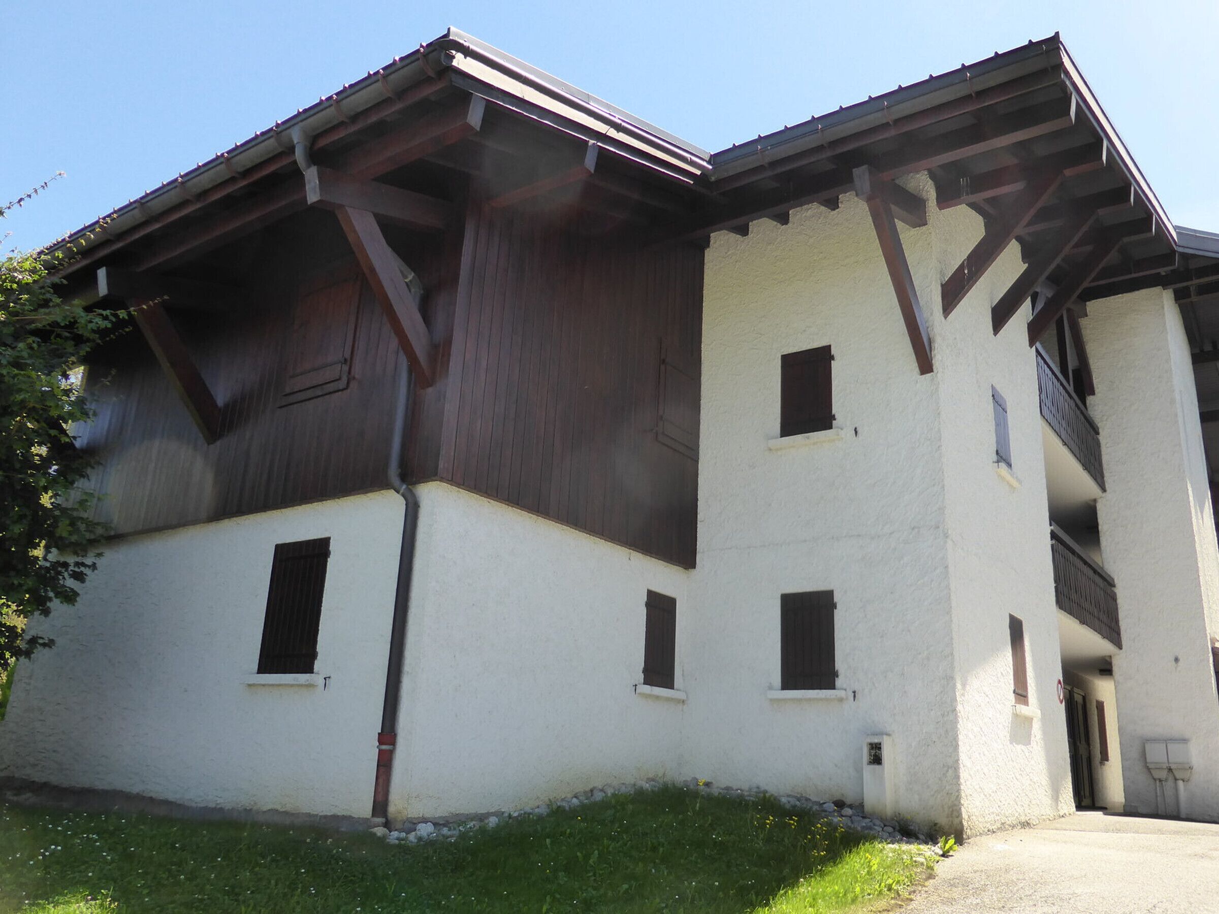A two-story building with a white facade and dark wooden beams.
