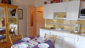 A compact kitchen with white cabinets, a microwave, and a coffee maker.