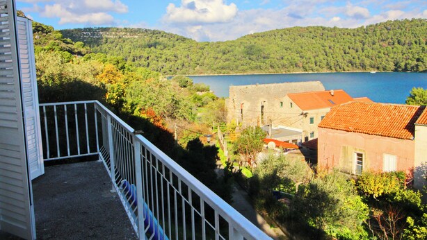 Ein Balkon mit Blick auf einen See und die umliegenden Hügel.