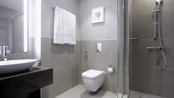 A modern bathroom with a large sink, toilet, and shower.