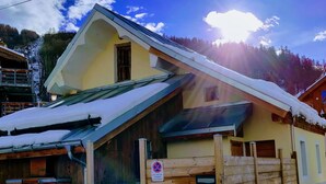 A wooden cabin with a sloped roof covered in snow, a small door, and a sign indicating no parking. - "Tigny House", private chalet in the heart of Valloire, 4 to 6 persons (Valloire)
