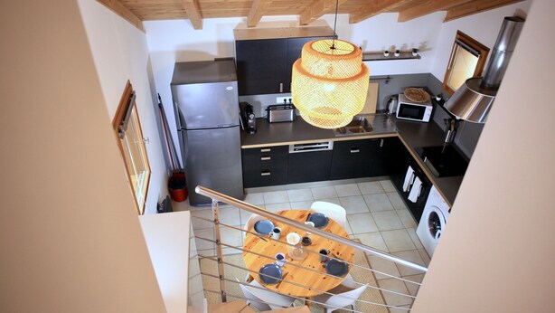 A modern kitchen with a dining area, a staircase, and a laundry machine. - "Tigny House", private chalet in the heart of Valloire, 4 to 6 persons (Valloire)
