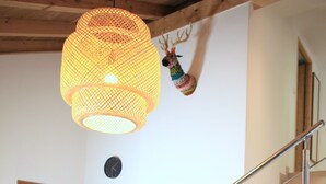 A dining area with a wooden table set for four, a staircase with a metal railing, and a wooden door. - "Tigny House", private chalet in the heart of Valloire, 4 to 6 persons (Valloire)