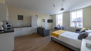 Un appartement moderne comprenant une cuisine, un coin repas et un grand lit.
