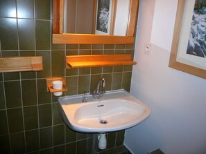 A bathroom with a white sink, wooden shelves, and a mirror. - 2-Room Duplex for 7 in Combloux with Parking (Combloux)