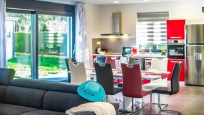 A modern kitchen with a dining area, large windows, and a view of the outdoors. - Villa Dolores (Vrsar)