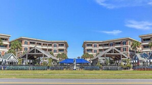 A hotel with a symmetrical facade, multiple balconies, and a central covered area with a blue roof. - Reba’s Retreat – A Charming Seacrest Beach Escape (Seacrest)