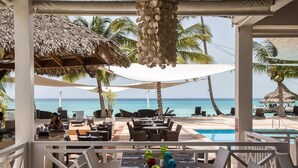 Ein Restaurant direkt am Strand mit Terrassenplätzen, einem Pool und Meerblick.