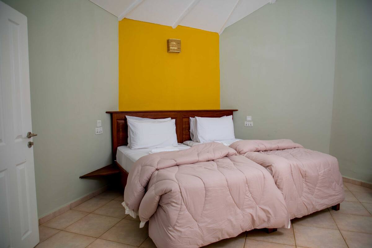 Une chambre à coucher comprenant un lit, une table de chevet et un luminaire fixé au mur.