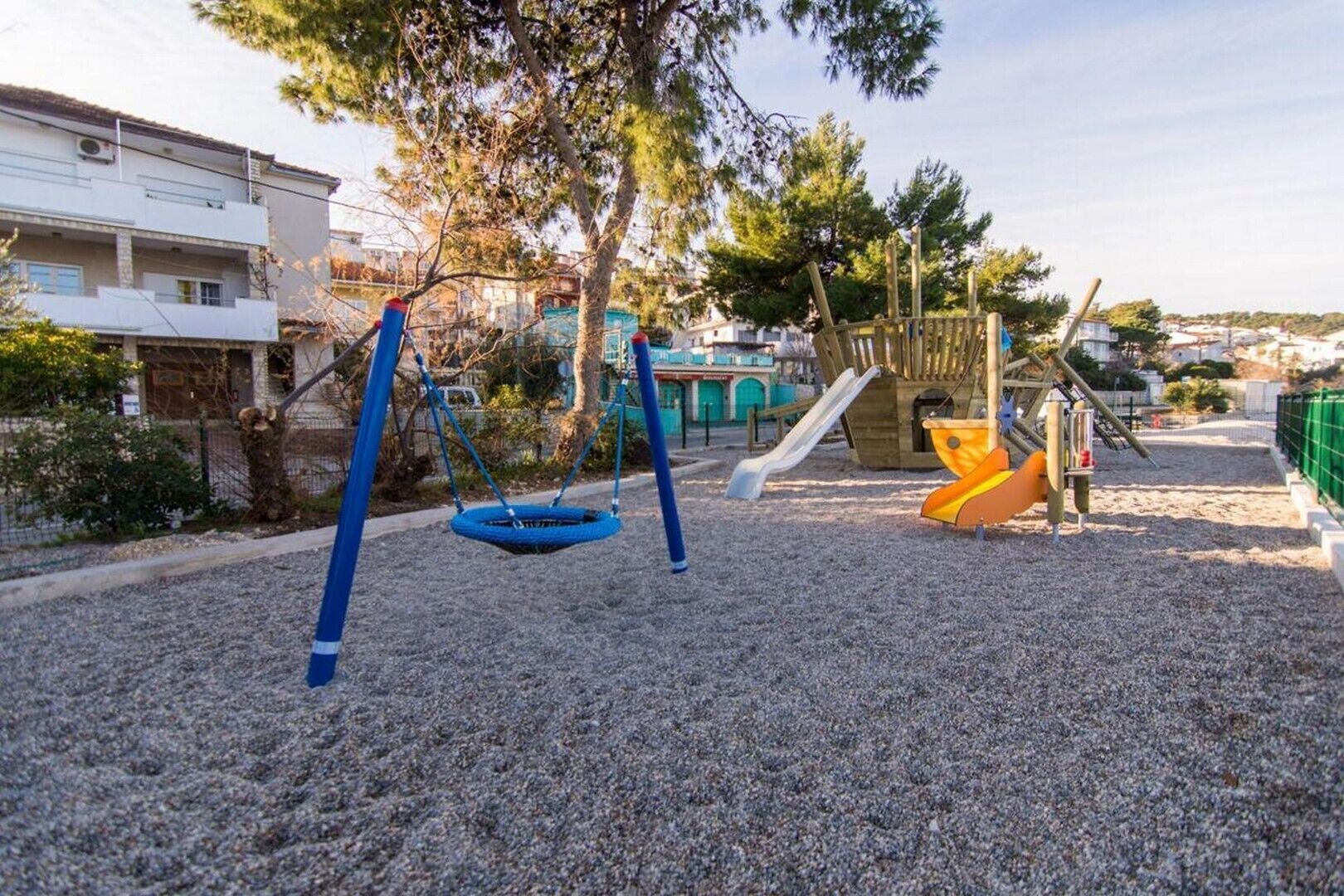 A playground with swings, a slide, and a climbing structure.