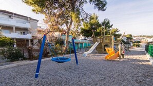 Un parque infantil con columpios, tobogán y estructura para escalar.