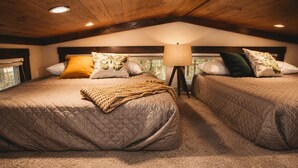 Een slaapkamer met twee bedden, een lamp en een raam.