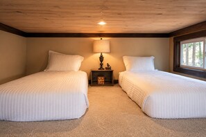 A bedroom with two beds, a nightstand with a lamp, and a window. - Cozy Cottage at The Retreat at Deer Lick Falls (Monteagle)