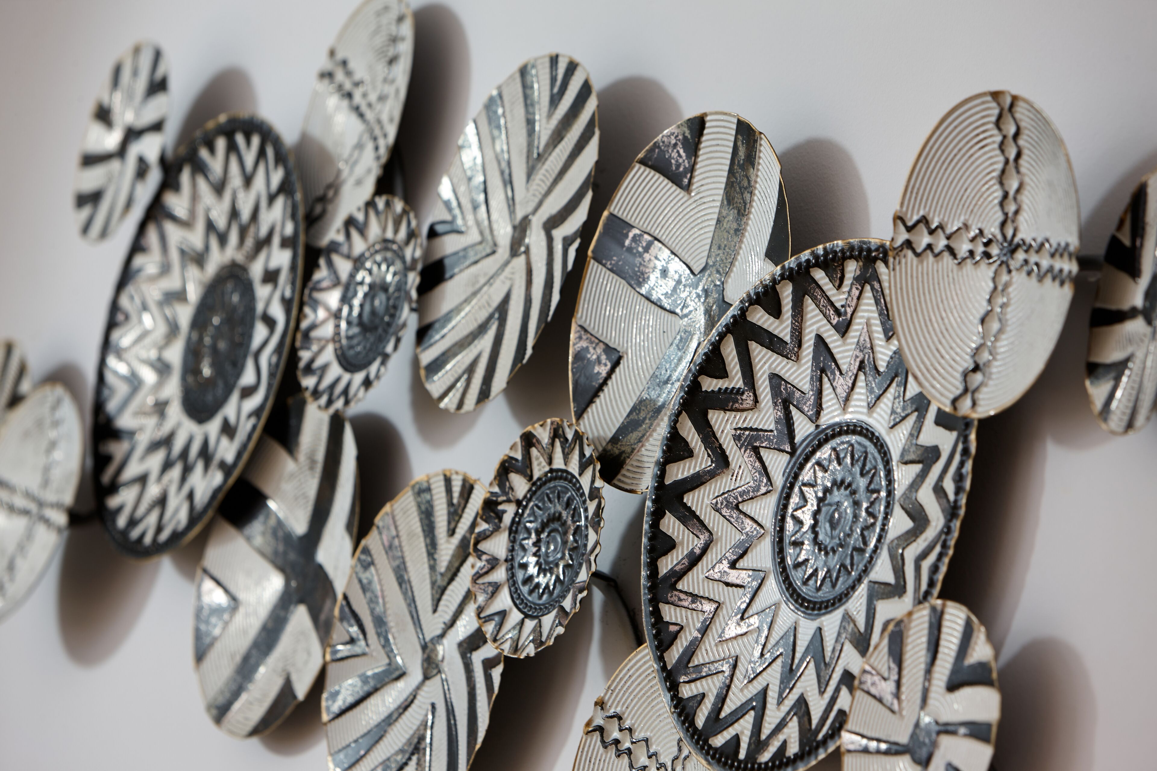 Une collection de plaques métalliques décoratives ornées de motifs et de dessins complexes.