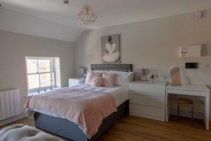 A bedroom with a bed, bedside tables, a desk, and a chair. - Apartment 9 Isabella House Hereford (Hereford)