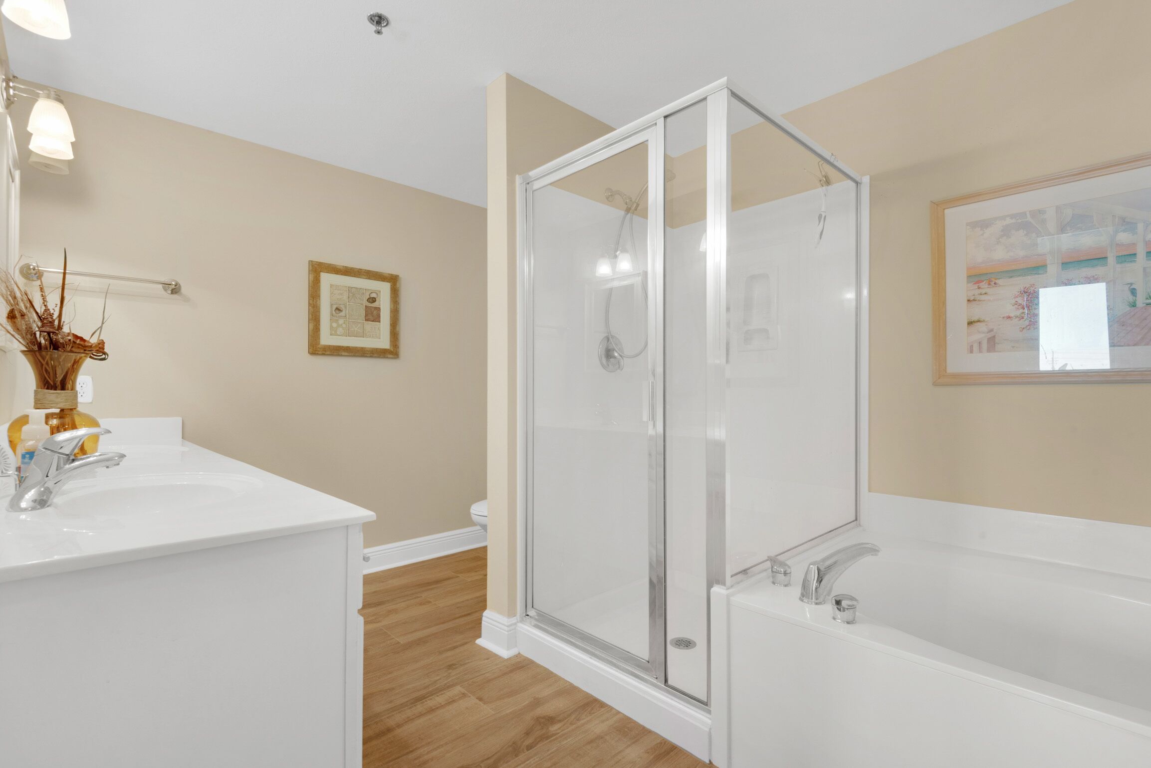 Une salle de bain moderne avec une douche à parois de verre, un lavabo blanc et une baignoire.