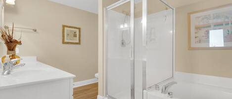 Une salle de bain moderne avec une douche à parois de verre, un lavabo blanc et une baignoire.