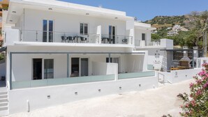 A modern two-story building with a balcony, large windows, and a flat roof.