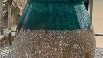 A large, speckled ceramic pot with a teal upper section, placed on a metal grate.
