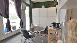 Et moderne køkken med spisebord, stole og kaffemaskine.