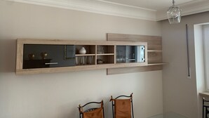 Una habitación con una estantería empotrada de madera, un ventilador de techo y dos sillas.