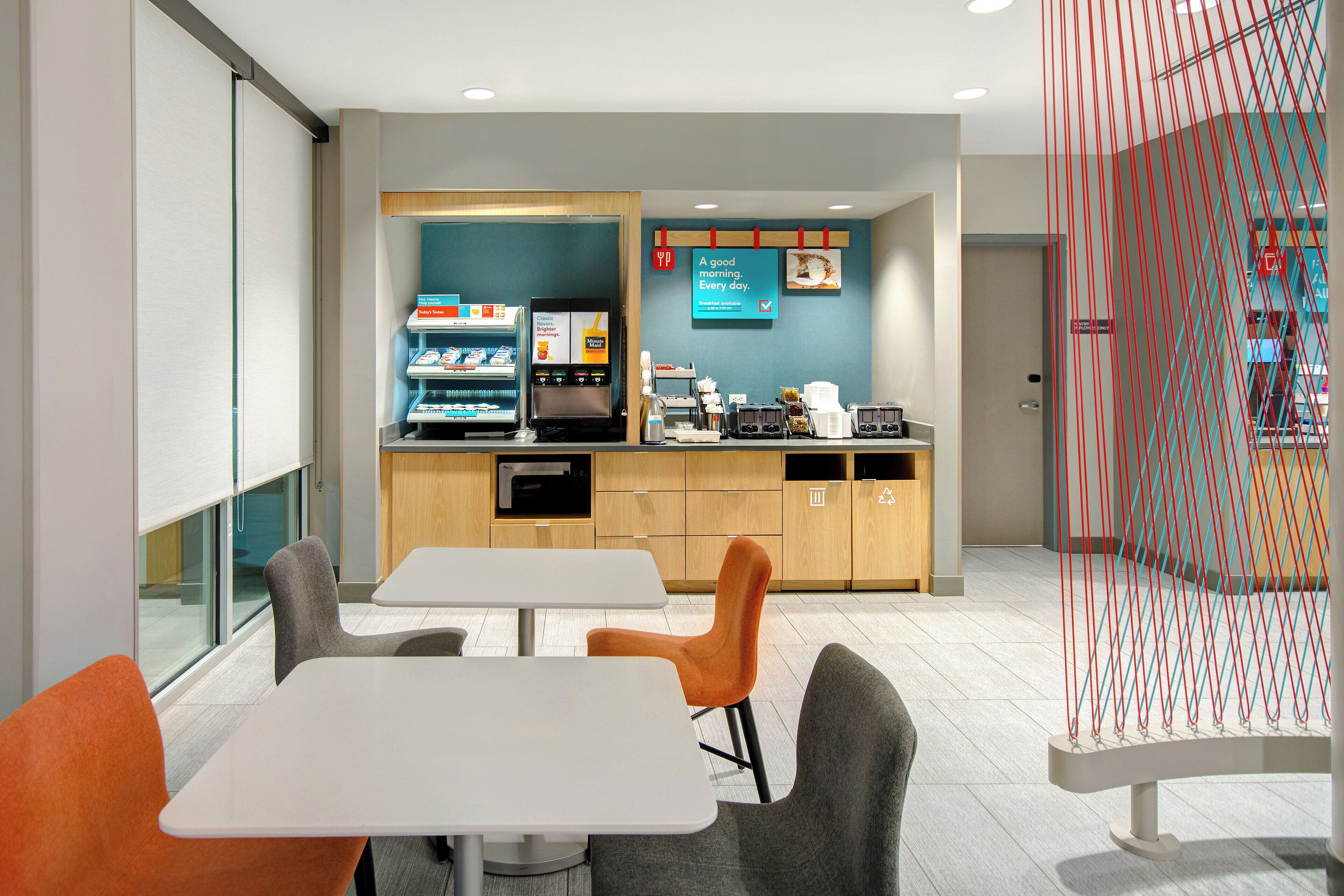 Un café moderno con mostrador, zona de estar y máquinas expendedoras.