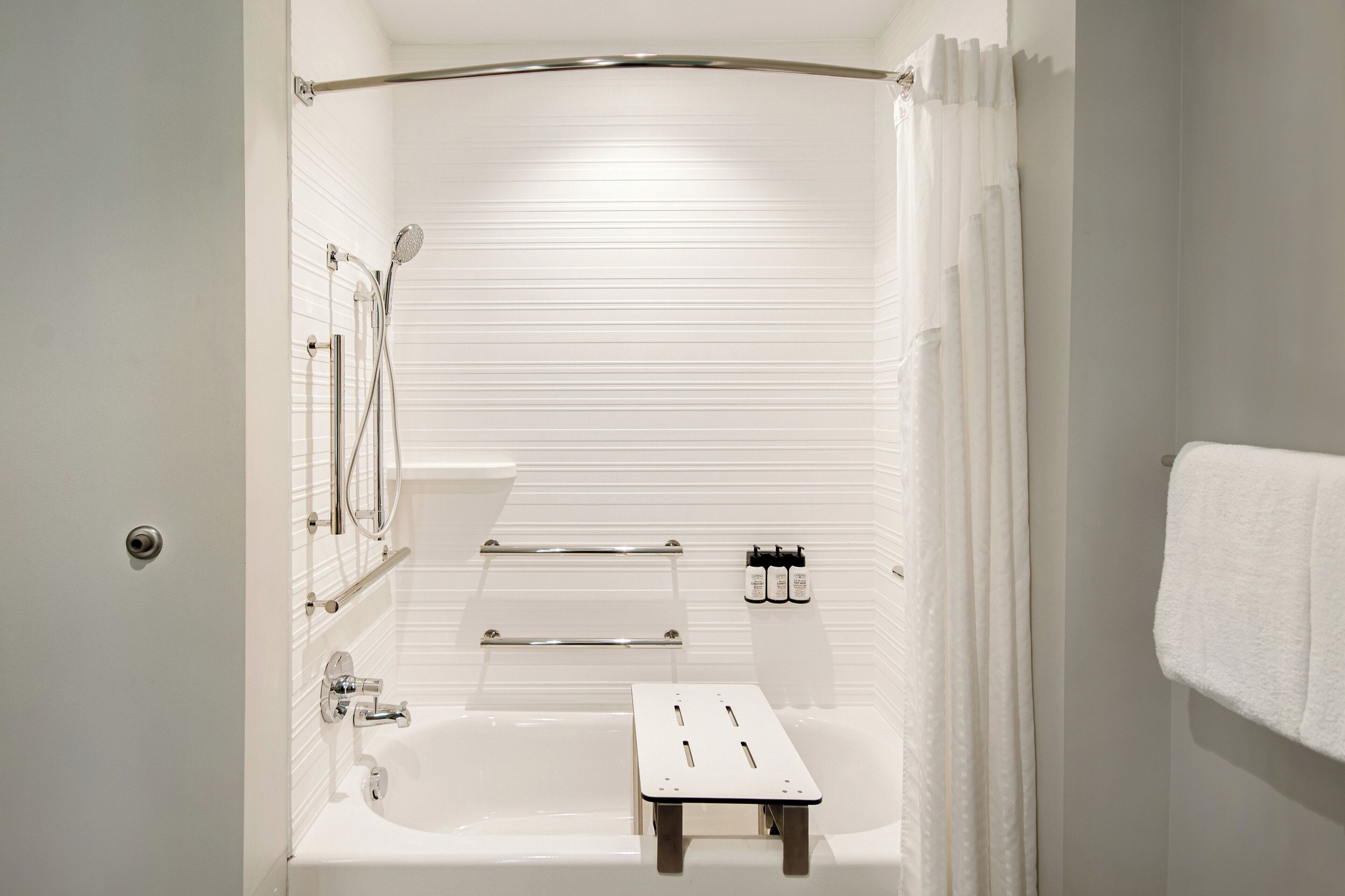A bathroom with a bathtub, a shower, and a towel rack.