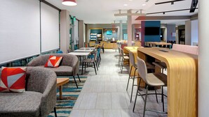 A modern, well-lit lounge area with comfortable seating, a bar, and a visible coffee machine. - avid Hotel Fort Mill - Carowinds Blvd by IHG (Fort Mill)