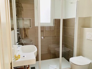Een douche, een bidet, handdoeken