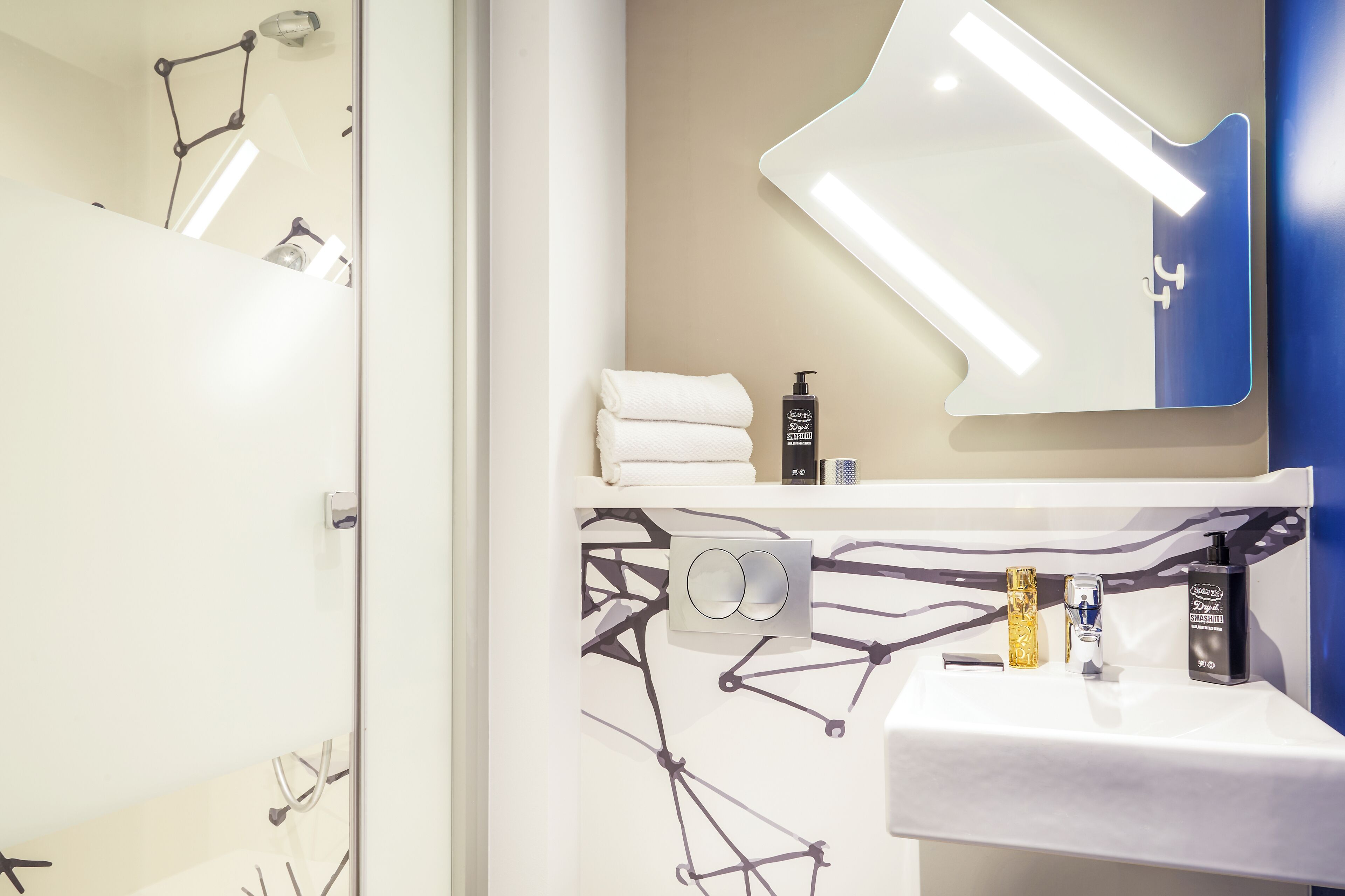 A modern bathroom with a white sink, a mirror, and a towel rack.