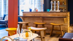 A bar area with wooden stools, a bar counter, and bottles. - ibis Styles Thonon Les Bains Hotel (Thonon-les-Bains)