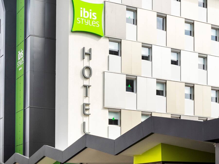 Un hôtel moderne, reconnaissable à son enseigne « ibis Styles » bien visible, à son entrée en verre et à sa façade épurée et contemporaine.