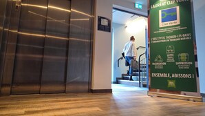 An elevator, a staircase, and a green sign with text about sustainable tourism. - ibis Styles Thonon Les Bains Hotel (Thonon-les-Bains)