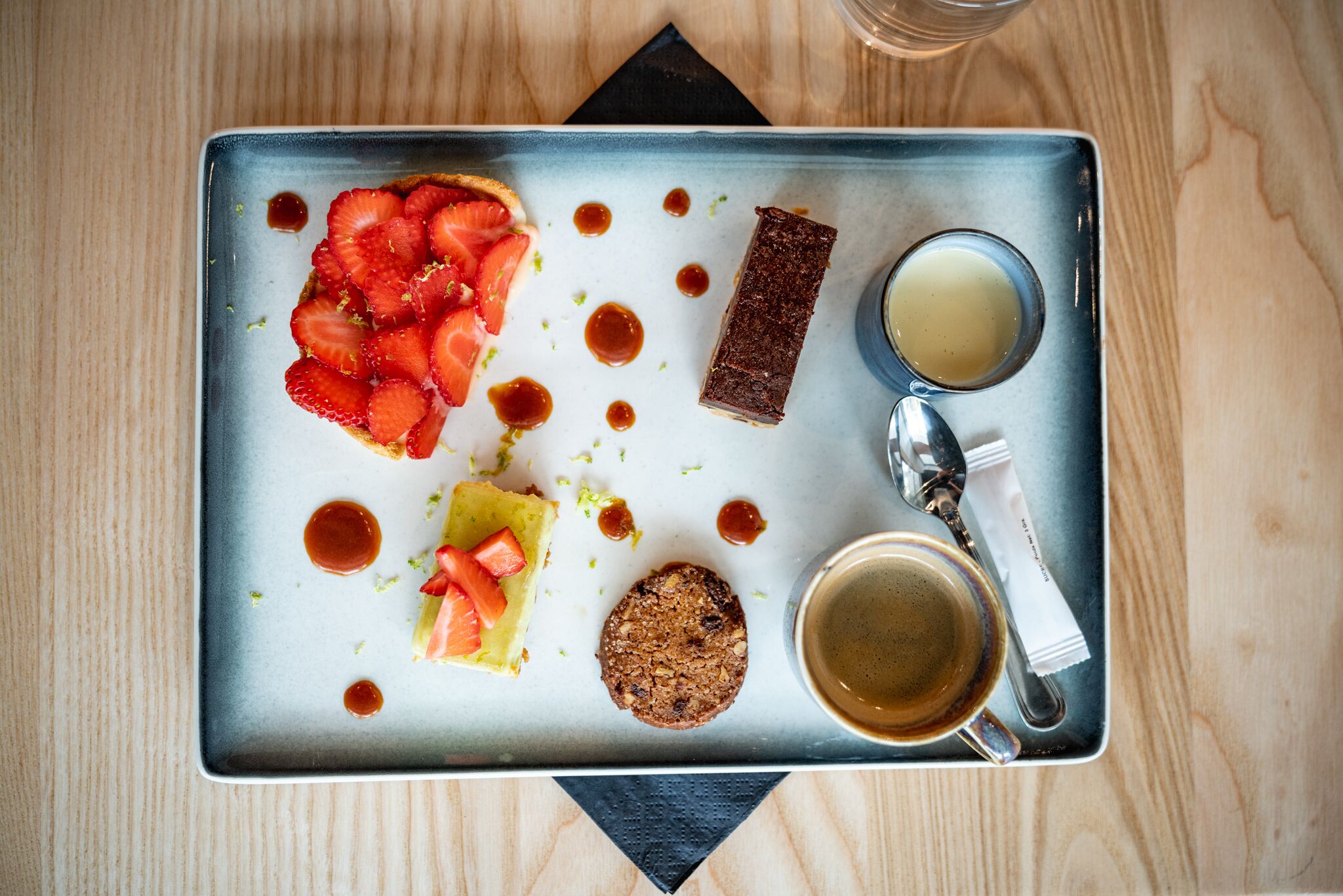 Een plateau met diverse lekkernijen, waaronder een stuk taart, een bolletje ijs en een kop koffie.