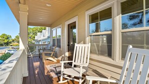 A covered porch with white rocking chairs and a view of a house. - Spacious family fun with game room, only 4 miles from East Beach! Relax + Enoy! (St. Simons Island)