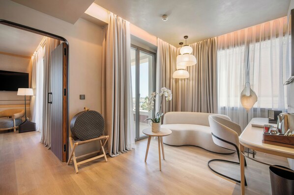 A modern hotel room with a sofa, a round table, a lamp, and a TV. - Only YOU Hotel Malaga (Málaga)