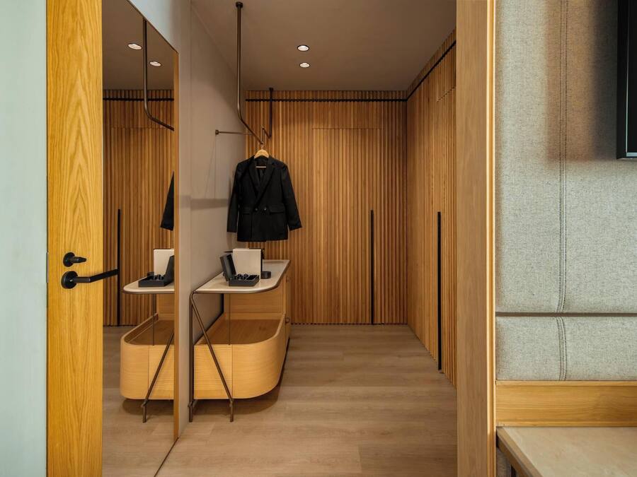 Une salle de bain moderne avec un meuble-lavabo en bois, un miroir et un porte-manteau suspendu.