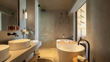 Un baño moderno con dos lavamanos, una bañera y cabina de ducha.